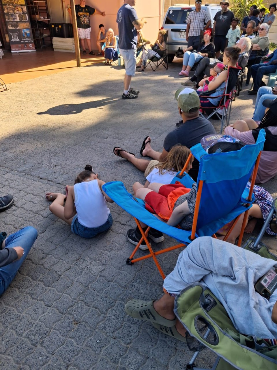 Crowd seated in camp chairs at the Penhill Snake Show