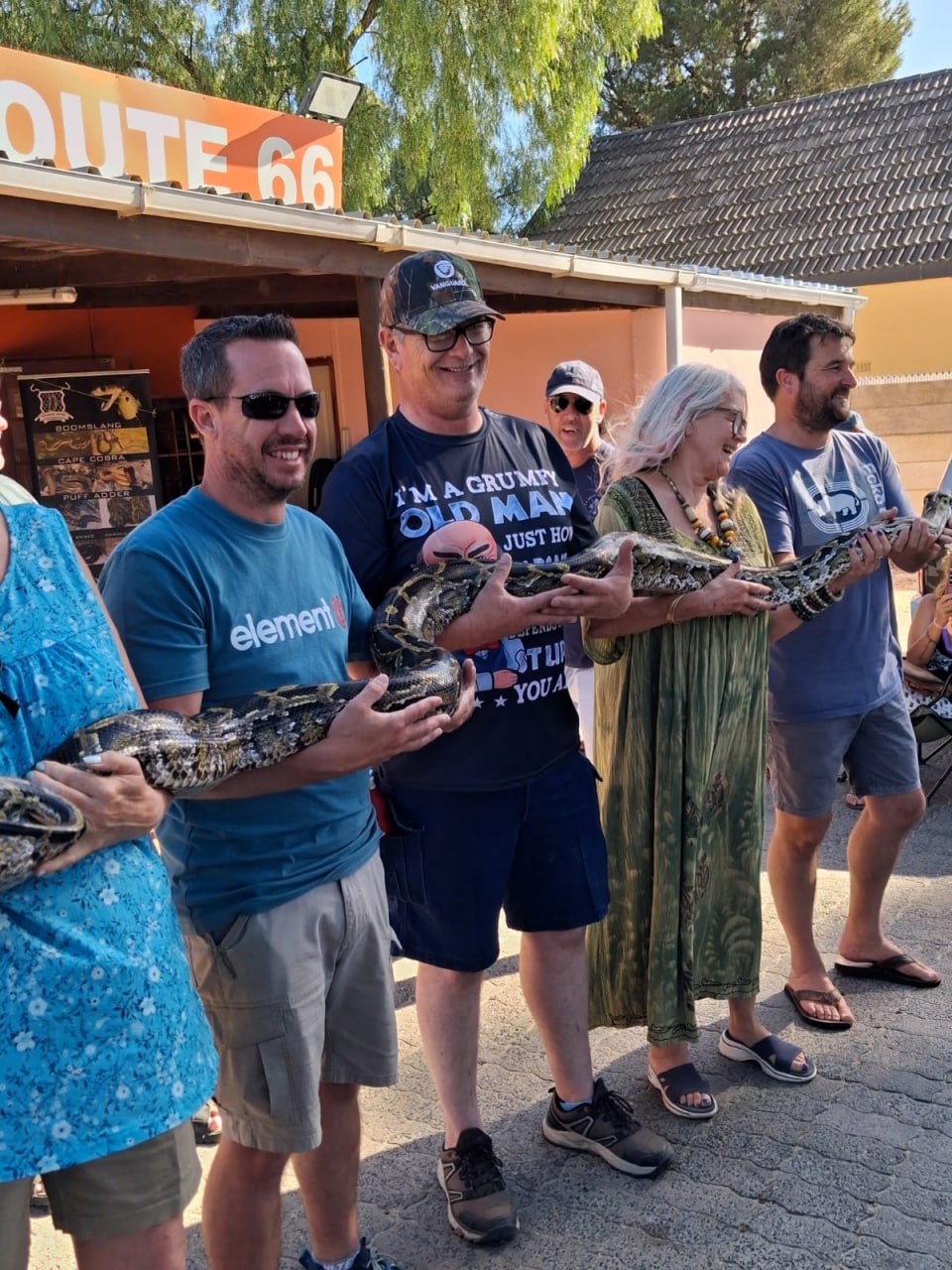 Group holding a large python at the Penhill Snake Show, next to the Route 66 venue